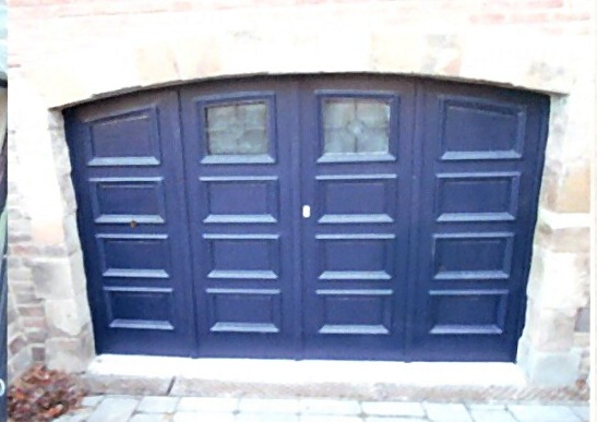 Porte de garage en bois restaurée et repeinte